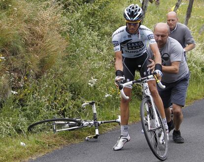 El corredor del Saxo Bank Alberto Contador, cambia de bicicleta tras una caída, empujado por un miembro de su equipo, ante la mirada del manager Bjarne Riis (al fondo), durante la novena etapa del Tour de Francia de 2011.