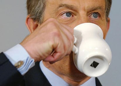 El primer ministro británico, Tony Blair, toma una bebida durante su conferencia de prensa de ayer en Londres.