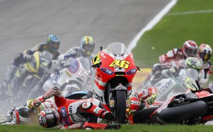 De izquierda a derecha, Randy de Puniet, Nicky Hayden y Valentino Rossi ruedan por el suelo. En medio, la moto del italiano.