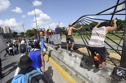 Activistas de la oposición venezolana derribaron una valla durante una protesta contra el gobierno frente a la base aérea Francisco de Miranda en Caracas.