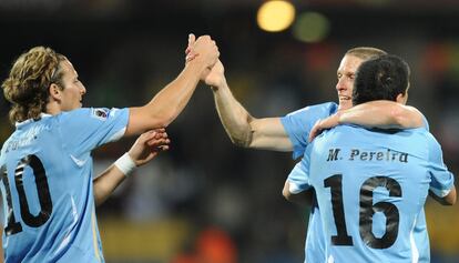 El delantero uruguayo, Diego Forlán, celebra con sus compañeros de selección el pase a los octavos como primeros de grupo.