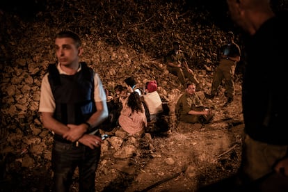 Varios israelís se protegen del bombardeo en el lateral de una carretera en Tel Aviv, este martes.