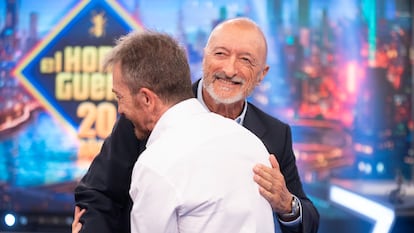 Pérez-Reverte y Motos se saludan.