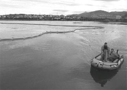 Colocación de barreras anticontaminación en la bahía de Txingudi (Guipúzcoa), junto a la frontera francesa.