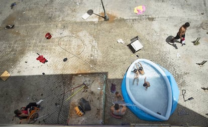 Um grupo de crianças brinca na piscina colocada no bairro 'Las 3000 Viviendas', em Sevilha, sul da Espanha