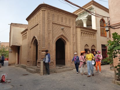 Un grupo de turistas chinos pasa junto a una mezquita clausurada en la ciudad antigua de Kashgar.