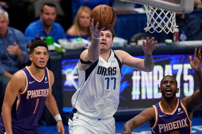 Luka Doncic lanza una bandeja ante la mirada de Devin Booker y Chris Paul.