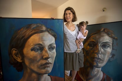 Lucie Geffré, pintora francesa, posa con su hija junto a dos de sus cuadros en su casa en Olmeda de las Fuentes.