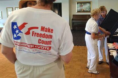 Una trabajadora electoral de un condado de Florida muestra a una mujer el funcionamiento de la máquina de voto.