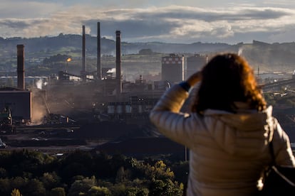 Una vecina mira hacia la acería de ArcelorMittal desde una zona de viviendas del oeste de Gijón.