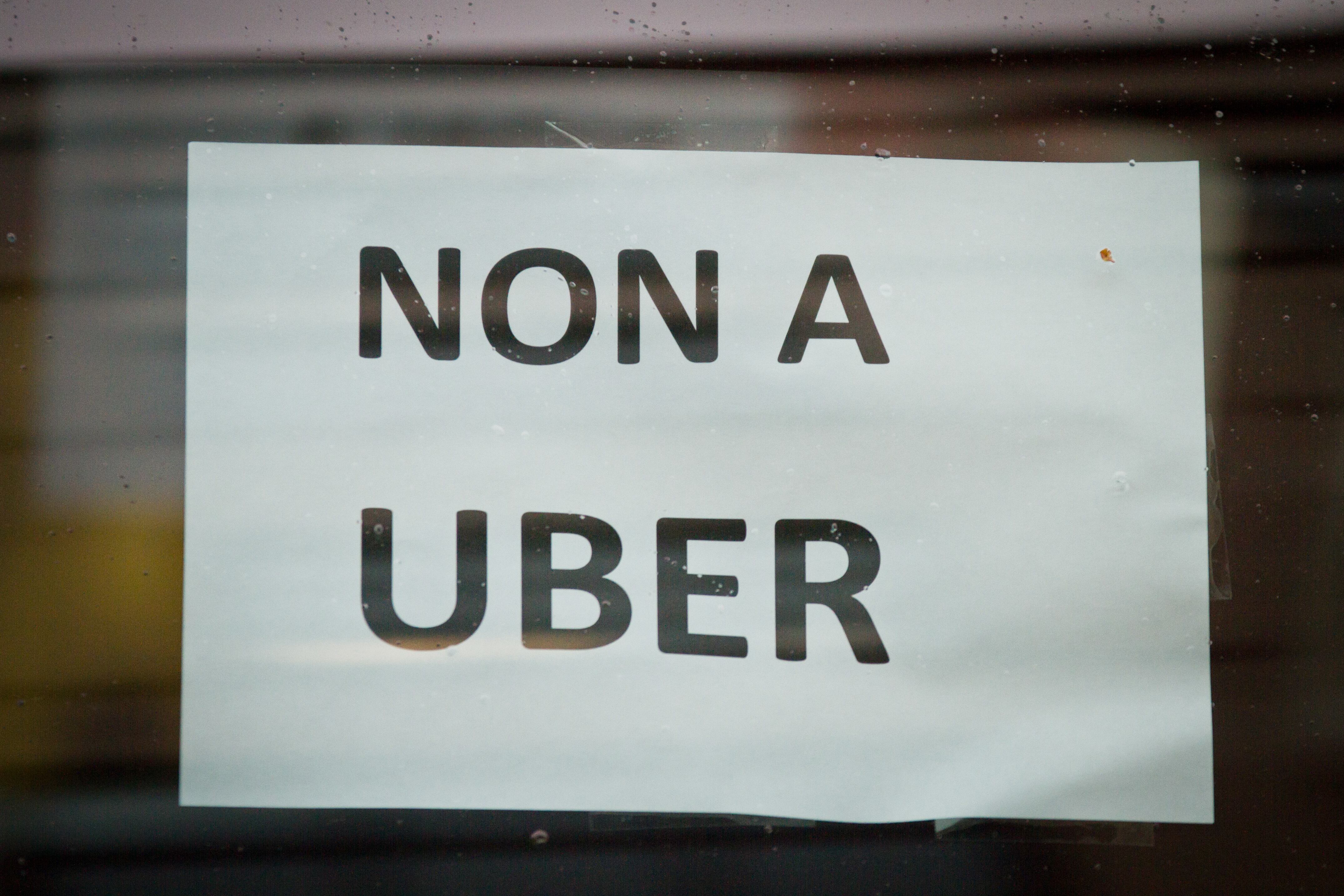 Durante una manifestación de alrededor de mil taxis y choferes en Bruselas (Bélgica), uno lleva en la ventana un letrero que lee 