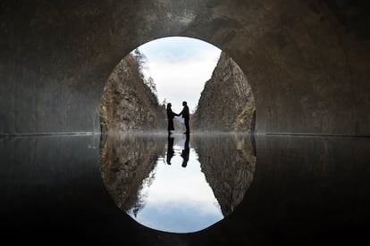 Dos visitantes posan para una fotografía en una plataforma de observación con la obra de arte 'Tunnel of Light' (Echigo-Tsumari Art Field) de Ma Yansong / MAD Architects en Kiyotsu-kyo Gorge, en Tokamachi, Japón.
