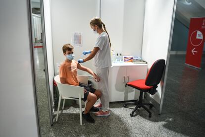 A health worker vaccinates a teenager in Valencia.