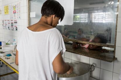 Los alumnos espera en fila mientras les sirven la comida.