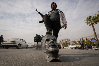 Um rebelde sírio pisa um busto do ex-presidente Hafez al-Assad, pai de Bashar al-Assad, neste domingo em Damasco.