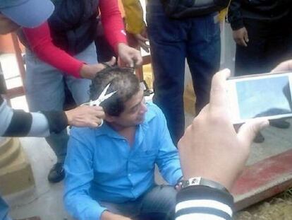 Alleged members of the CNTE clip off a teacher's hair in Chiapas.