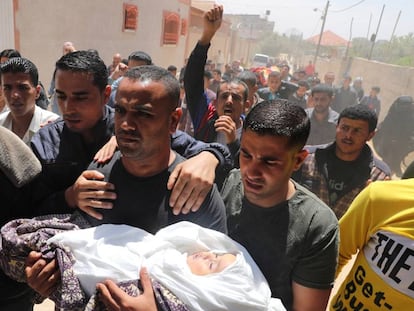 Pai de menina morta por um projétil leva a filha para o funeral, neste domingo, em Gaza.