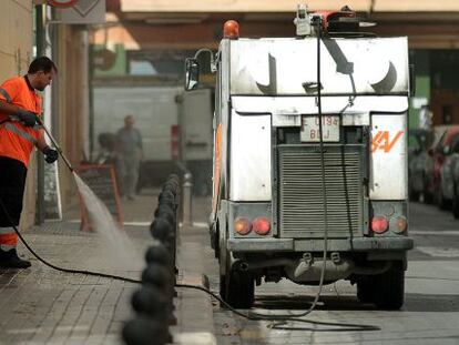 Un trabajador de Sociedad de Agricultores de la Vega realiza tareas de baldeo en una calle de Valencia.