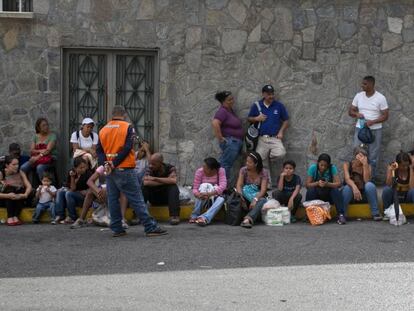 Um grupo de venezuelanos faz fila em frente a um supermercado de Caracas.