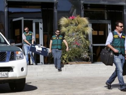 Unos guardias salen tras un registro en el Ayuntamiento madrile&ntilde;o de Collado Villalba.