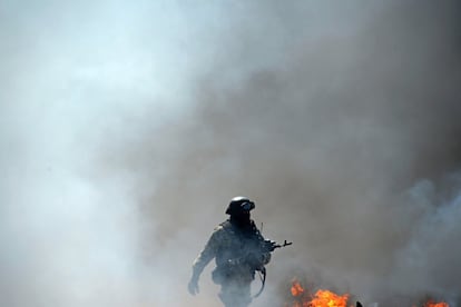 Um soldado ucraniano passa diante de um posto de controle incendiado por forças pró-russas em Slaviansk.