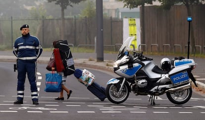 A woman carries her belongings past a police officer as some 60,000 people in Germany's financial capital are about to evacuate the city while experts defuse an unexploded British World War Two bomb found during renovations on the university's campus in Frankfurt, Germany, September 3, 2017.  REUTERS/Kai Pfaffenbach