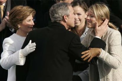 George Bush abraza a su esposa, Laura, y a sus hijas, Barbara y Jenna (de izquierda a derecha), tras su juramento.