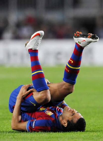 Alves se queja sobre el césped de la lesión que sufrió.