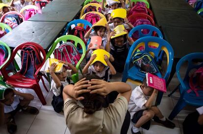Escolares participan en un simulacro de terremoto a escala nacional en Manila, Filipinas.