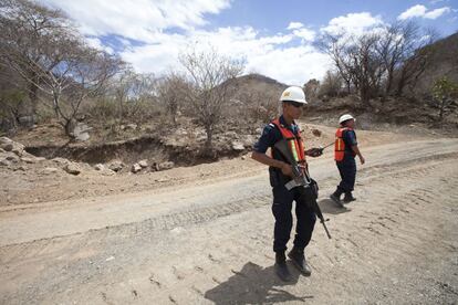 Dos agentes de la seguridad privada de la mina hacen guardia en uno de los accesos