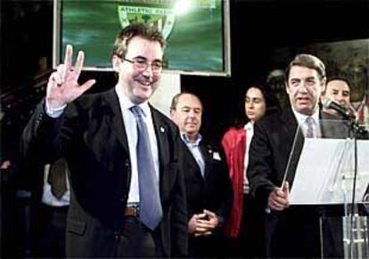 Javier Uría saluda con la uve de la victoria mientras le observa el presidente saliente, José María Arrate.