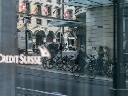 Un ciclista pasa ante el escaparate de una sucursal de Credit Suisse en Ginebra.