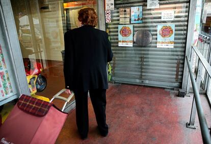 Una dona davant de les portes del Mercat de Sant Antoni que roman tancat per la vaga.