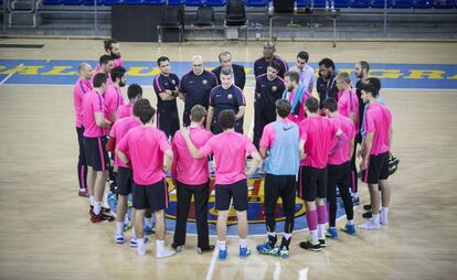 Los jugadores del Bar&ccedil;a, en el Palau, en torno a Xavi Pascual.