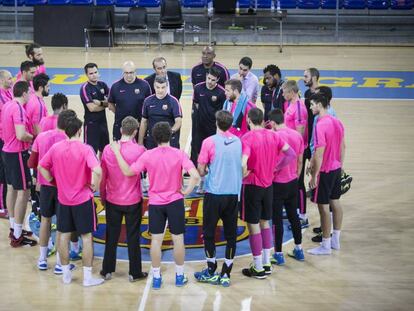 Los jugadores del Bar&ccedil;a, en el Palau, en torno a Xavi Pascual.