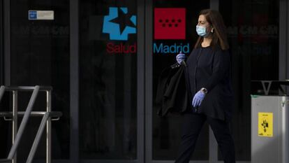 Una mujer sale del Hospital La Paz, en Madrid, protegida con guantes y mascarilla. / PABLO BLAZQUEZ (GETTY IMAGES)