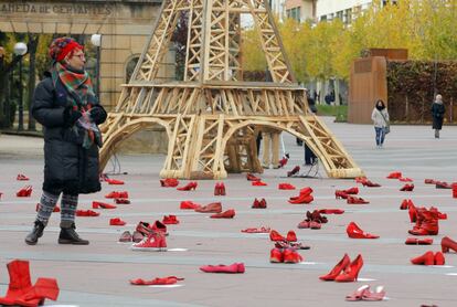 Una mujer camina por la plaza de Mariano Granados llena de zapatos en recuerdo a las víctimas de violencia machista.