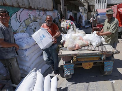 Varios hombres cargan sacos de harina suministrados por la Agencia de la ONU para los Refugiados Palestinos en el campo de refugiados de Al-Shati, en la Franja de Gaza, este 5 de junio.