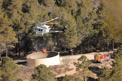 Dotaciones de bomberos y un helicóptero trabajan en la extinción del incendio en la zona de los Peiros, en la provincia de Teruel, este sábado.