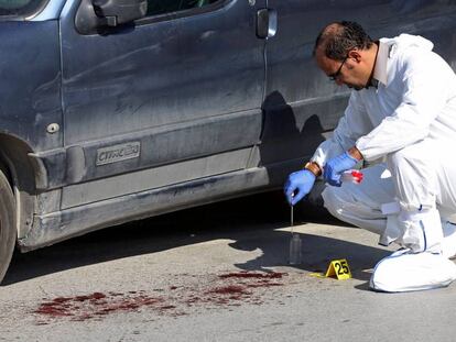 Un polic&iacute;a forense tunecino trabaja en el lugar donde un terrorista apu&ntilde;al&oacute; a dos agentes de polic&iacute;a