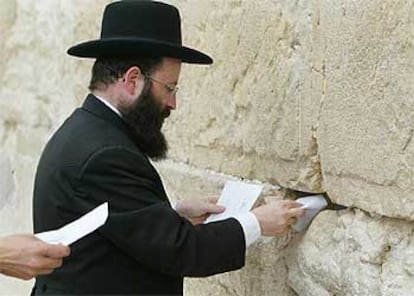 El rabino Samuel Rabinovich coloca mensajes a Dios en el Muro de las Lamentaciones ayer en Jerusalén.