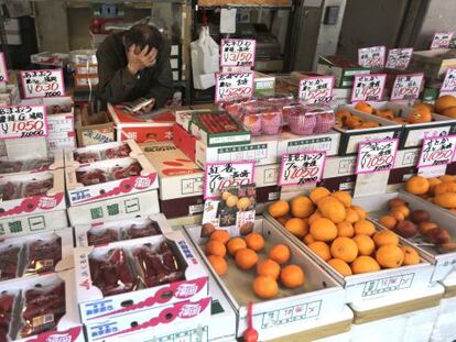 Un frutero espera a su casi inexistente clientela en un mercado de Tokio.
