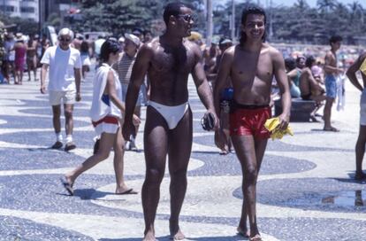 Dois homens passeiam pela avenida Atlântica da praia de Copacabana, um dos lugares preferidos dos cariocas. Sua calçada, obra do paisagista Burle Marx, é um dos elementos mais reconhecidos da cidade e, por sua extensão, de 4,5 quilômetros, é considerada uma das maiores obras de arte urbana.