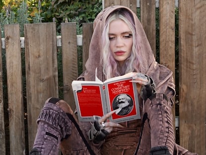 Grimes, fotografiada en una calle de Los Ángeles, California, leyendo 'El manifiesto comunista' de Karl Marx.