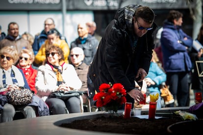 Un hombre enciende una vela durante un homenaje por el 20º aniversario del 11-M, este lunes junto a la placa conmemorativa de la calle Téllez, en Madrid.