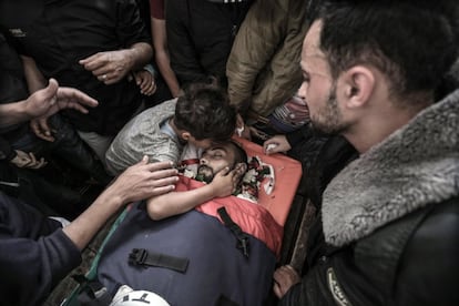 Un niño besa el cuerpo sin vida del periodista palestimo Ahmad Abu Hussein durante su entierro en el campo de refugiados Jabaliya al norte de la Franja de Gaza (Palestina).