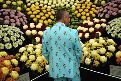 Un vendedor vestido para la ocasión junto a su puesto de flores.