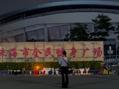 Una mujer ante ramos de flores dejados en memoria de las víctimas del atropello masivo junto a un centro deportivo de Zhuhai, en el sur de China, el 12 de noviembre de 2024.