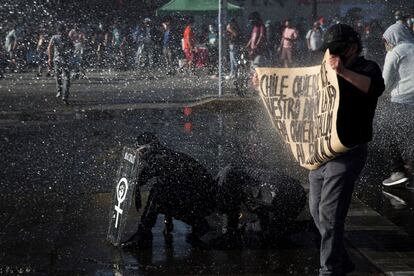 Manifestantes y Carabineros se enfrentan hoy durante una protesta cerca al Palacio de La Moneda, en Santiago (Chile). Cientos de personas se congregaron este miércoles en los alrededores del Palacio de La Moneda para protestar contra el Gobierno y exigir la renuncia del presidente, Sebastián Piñera, así como la libertad de los ciudadanos encarcelados durante las protestas que han sacudido al país austral desde octubre de 2019.