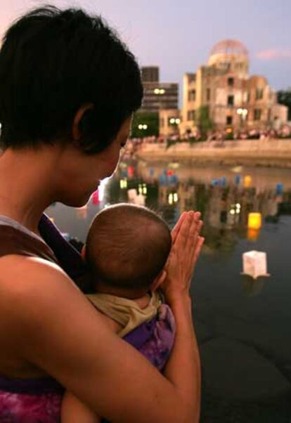 Una mujer japonesa sostiene a su hijo mientras reza por las víctimas de Hiroshima.